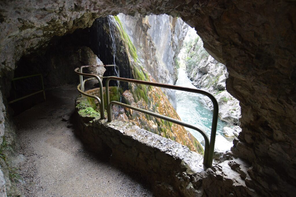 Túnel excavado en la roca en la Ruta del Cares, abierto sobre la garganta y el río