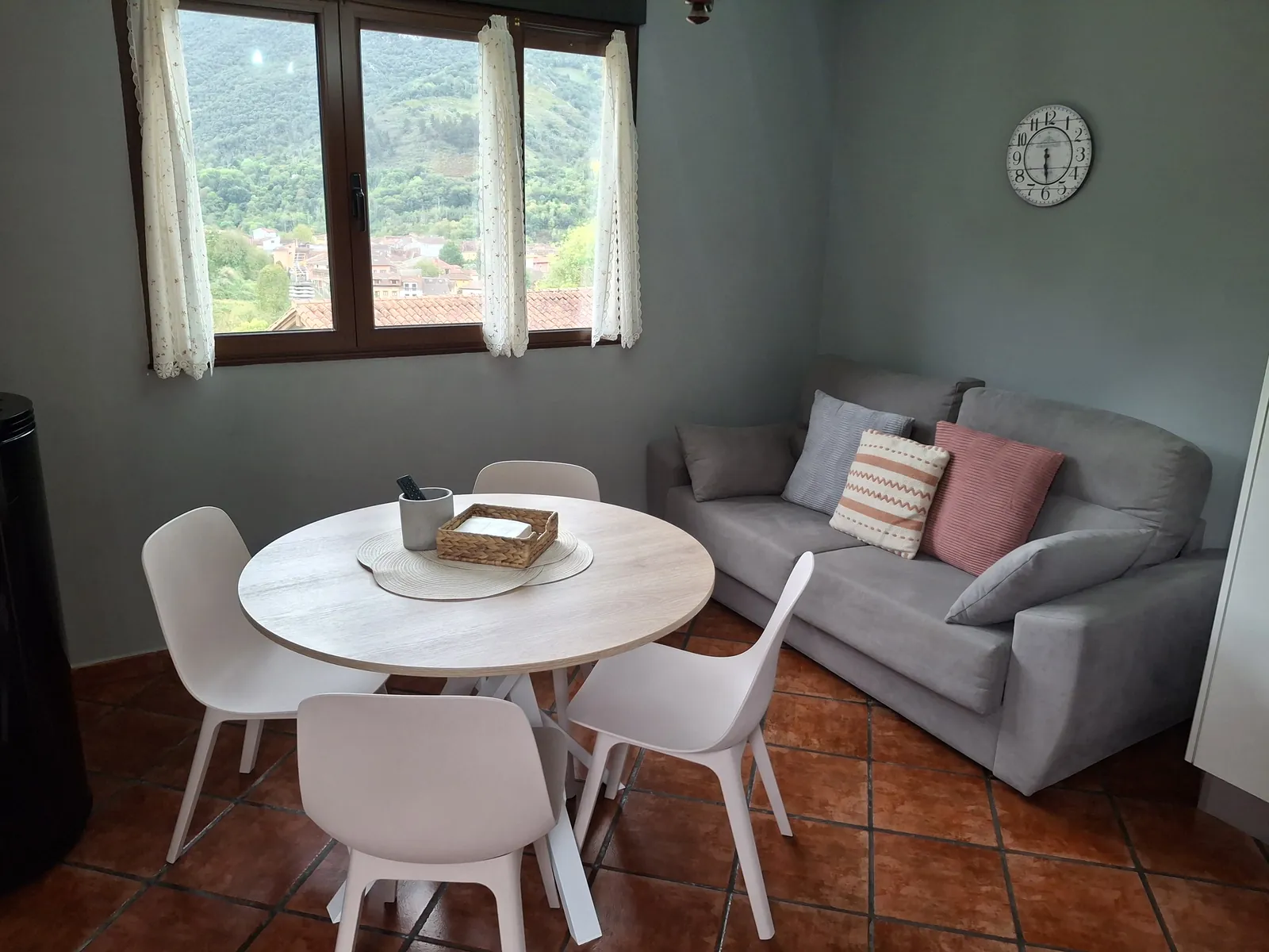 Ground-floor living and dining room in the Cares apartment, with a sofa and a round table