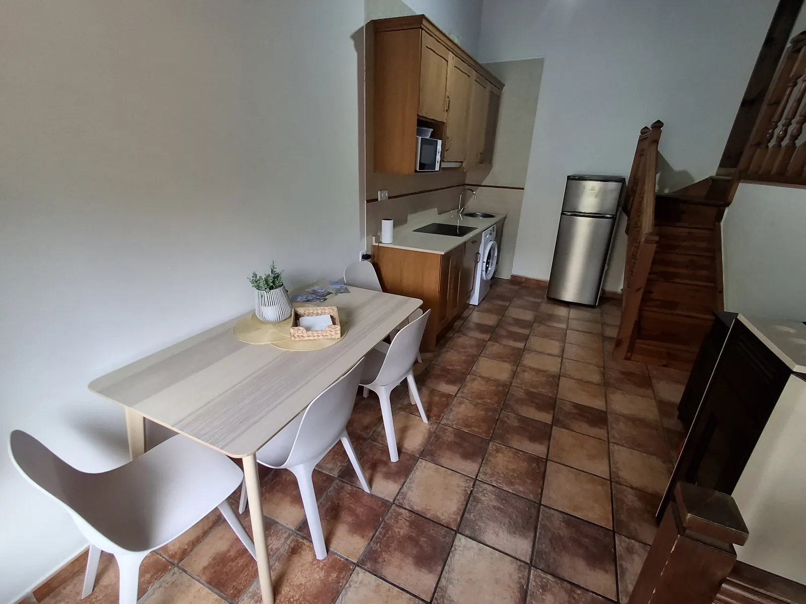 Ground-floor kitchen and dining area of La Casina, with the wooden staircase behind