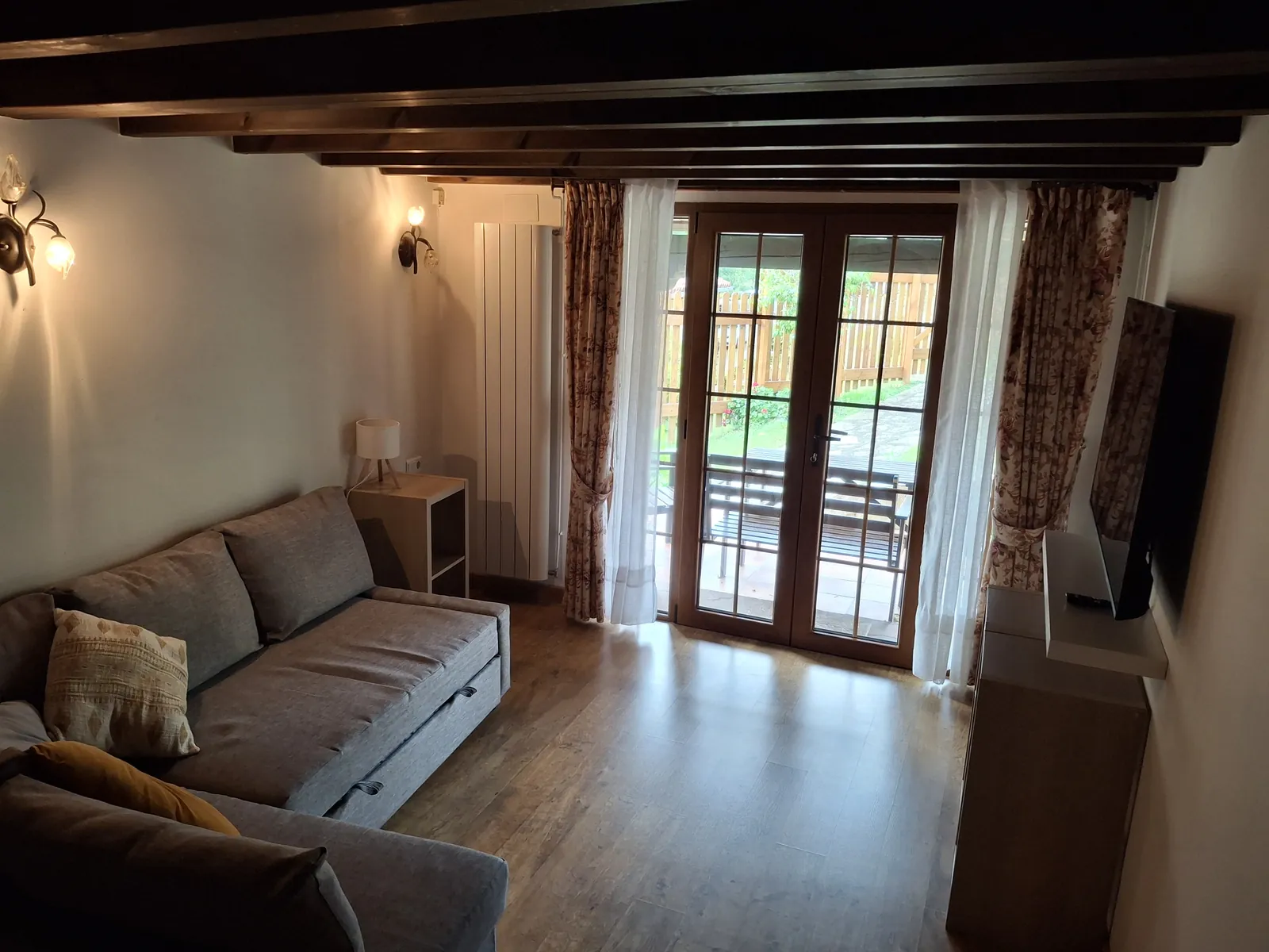 Living room of La Casina, with a sofa bed and glazed doors onto the porch